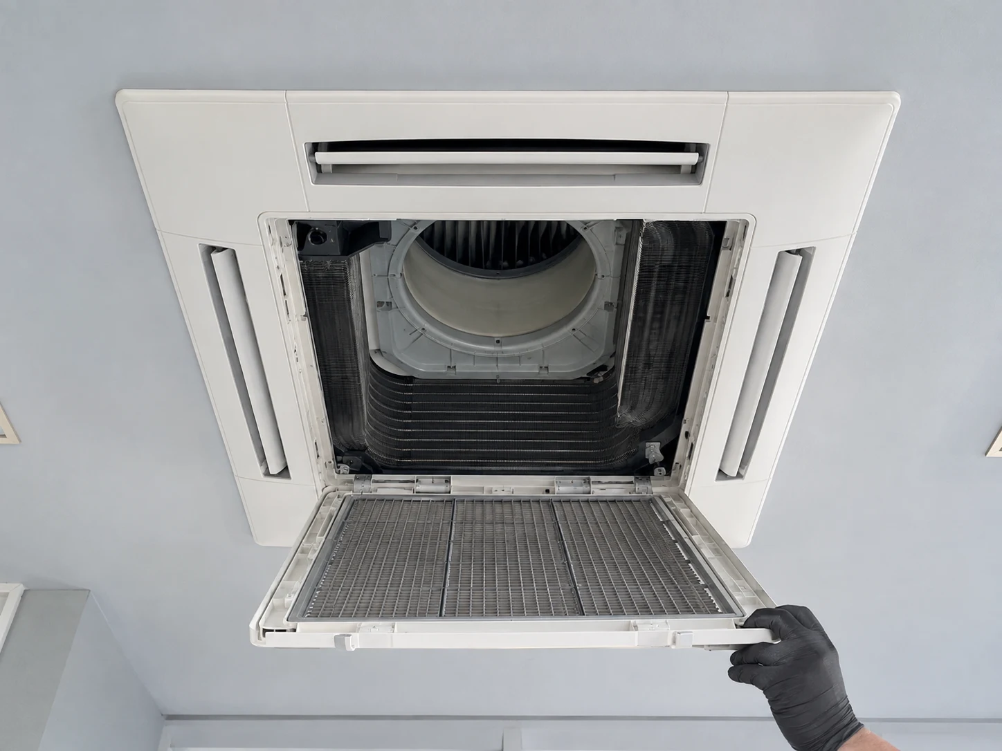 Generated editorial view of an open ceiling cassette and hinged grille, illustrating components and cleaning access