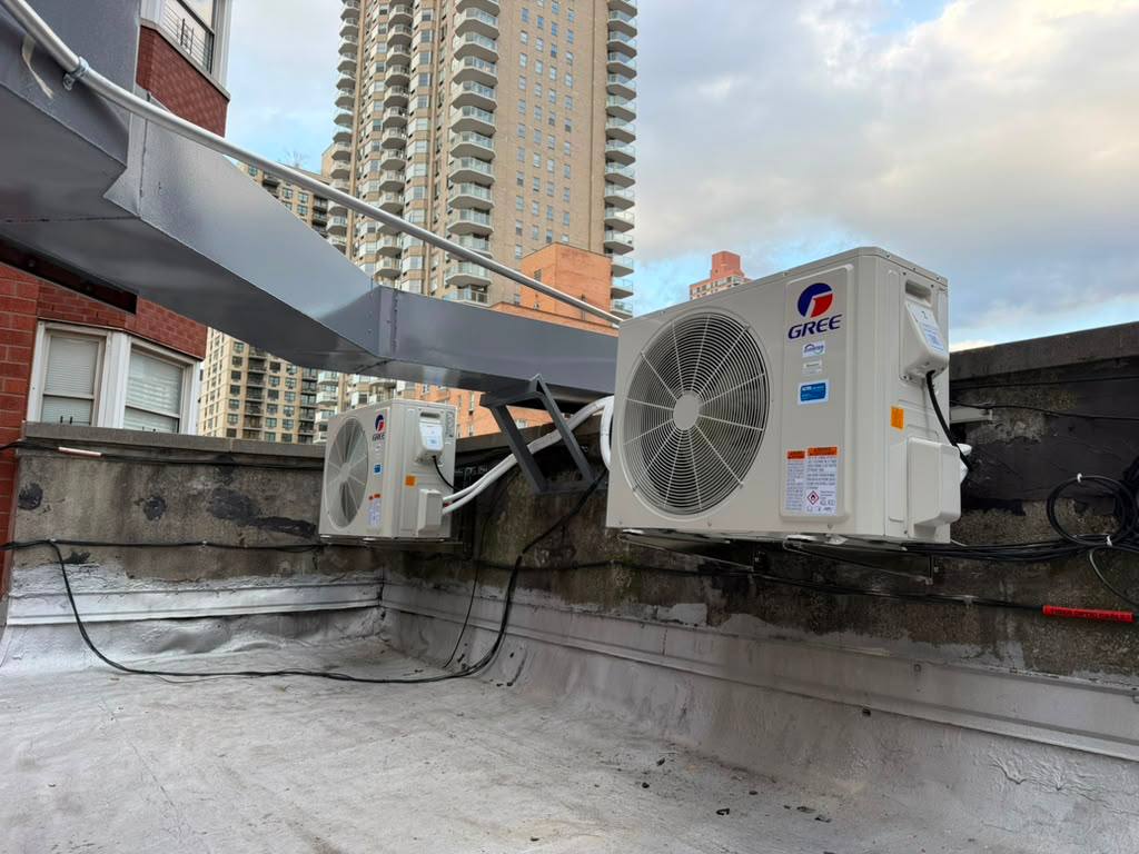 Two outdoor Gree units mounted near rooftop ductwork