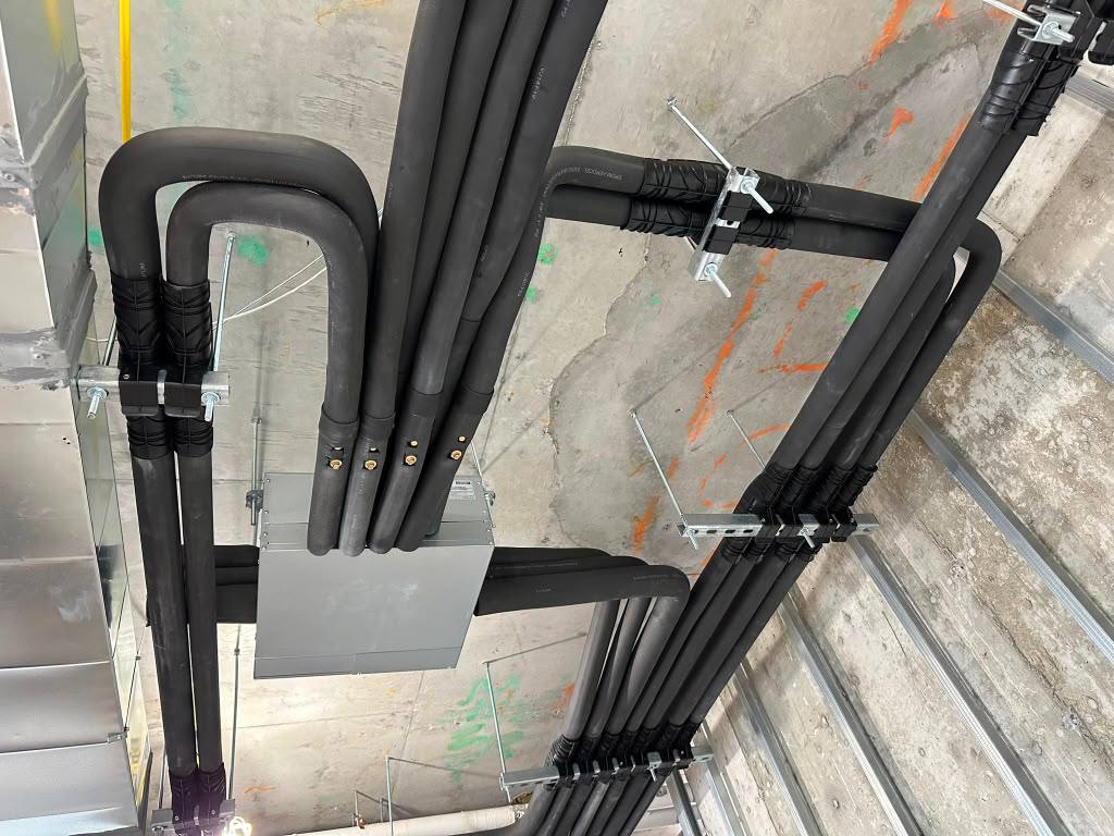 Insulated HVAC lines and distribution boxes above a ceiling